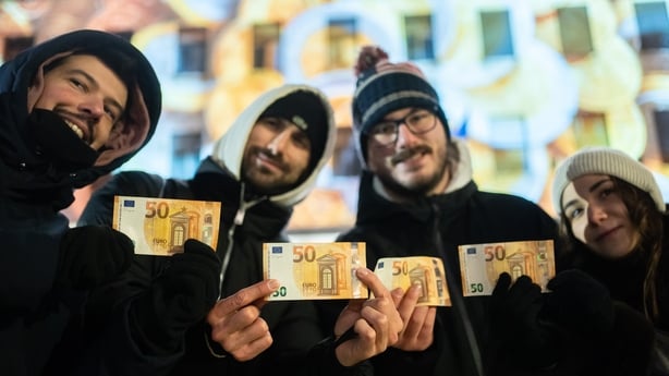 tourists pose with their euro notes in front of the Bulgarian National Bank 