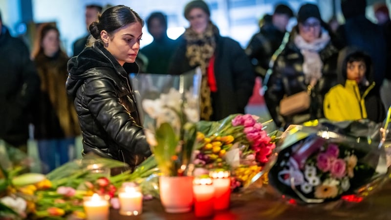 A woman lays flowers near the site of the fire in Crans-Montana