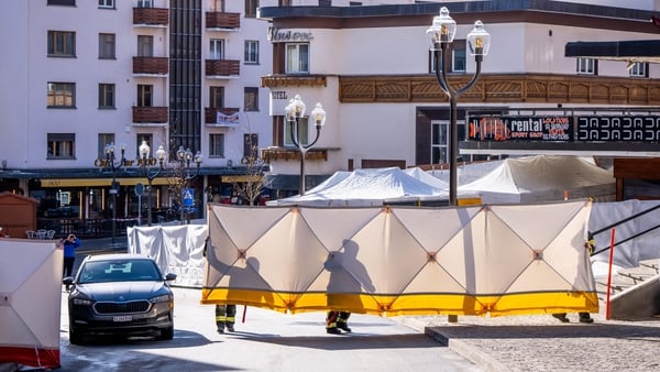 Police officers and firefighters set up folding screensa around a building