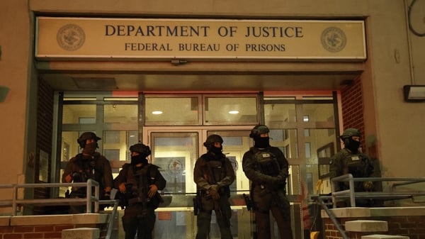Armed police stand guard outside a building