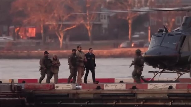 screengrab shows nicolas maduro surrounded by armed officers being brought to a helicopter