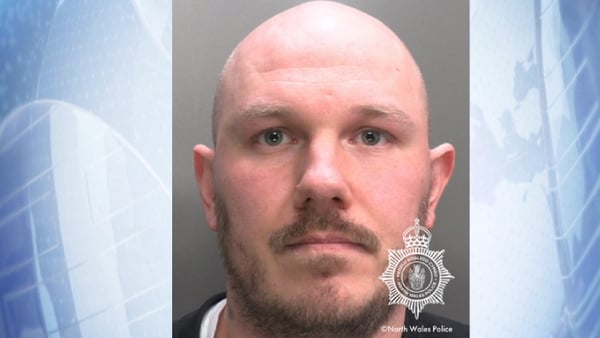 Bald man with blue eyes named Miles Cross has his photo taken by north Wales Police