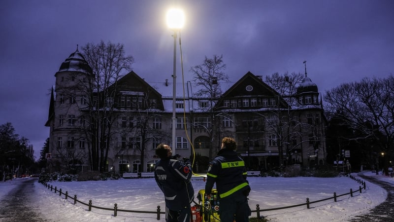 German Federal Agency volunteers set up a generator-operated street light in Berlin following last weekend's arson attack on power cables