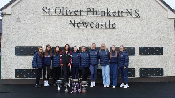 Athenry Team standing outside Newcastle National School with trophies.