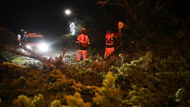 Workers clear a road from fallen trees after the passing of the Storm Goretti in Banville, northwestern France 