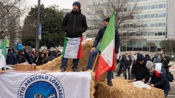 Farmers stand on hay bales during a demonstration 
