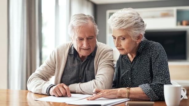 senior couple sitting together looking at paperwork