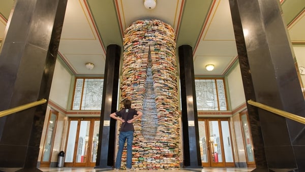 A woman looks at the Idiom installation, created by Slovakian artist, Matej Kren. The Idiom installation, is a cylindrical tower made of books