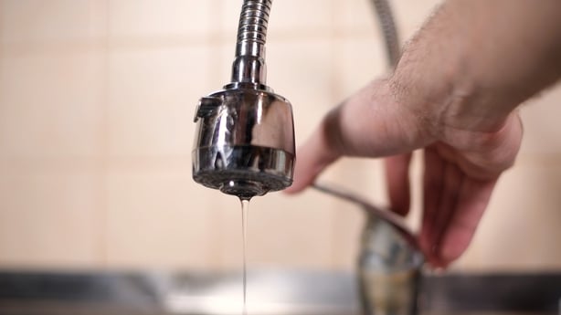 A man opens a faucet in the kitchen, but no water comes