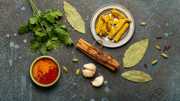 Herbs and spices traditional for Indian cuisine arranged on a rustic background for your culinary designs 