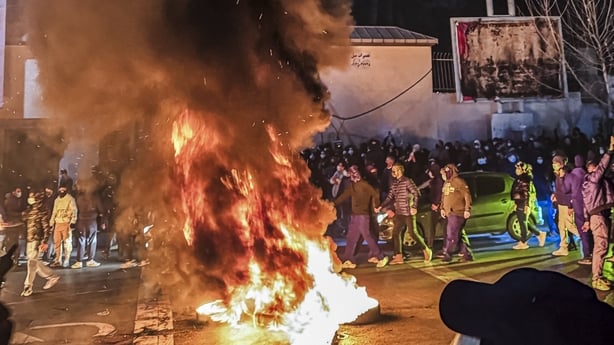 Iranians gather while blocking a street during a protest in Tehran, Iran