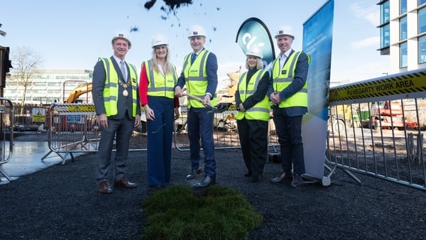 Five people wearing hi-vis jackets pose for a photograph
