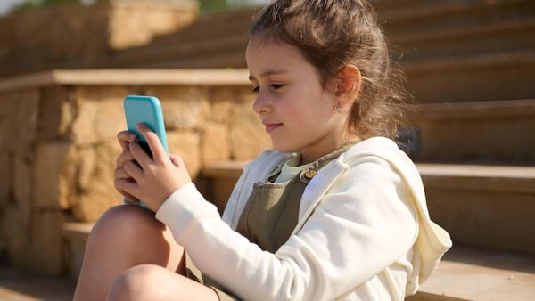 A young girl looking at a mobile phone