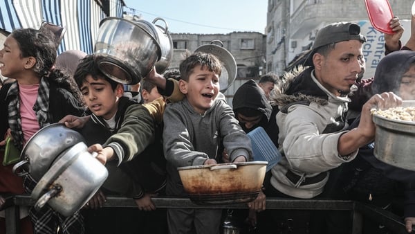 Palestinians gather to receive hot meal, distributed by charity organizations