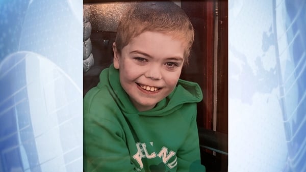 A picture of Nicholas Power smiling wearing a green hoodie