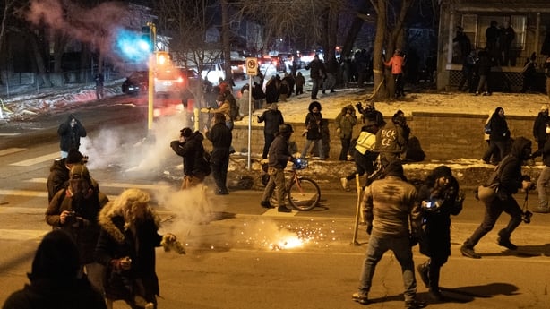 People run in several directions as federal agents launch tear gas at residents protesting in Minneapolis