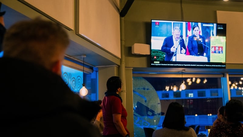 People watch a press conference with in Nuuk showing Danish Foreign Minister Lars Lokke Rasmussen and his Greenlandic counterpart Vivian Motzfeldt after their White House meeting