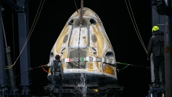 Support teams onboard the SpaceX recovery ship work around the SpaceX Dragon Endeavour spacecraft shortly after it landed with NASA astronauts in the Pacific Ocean
