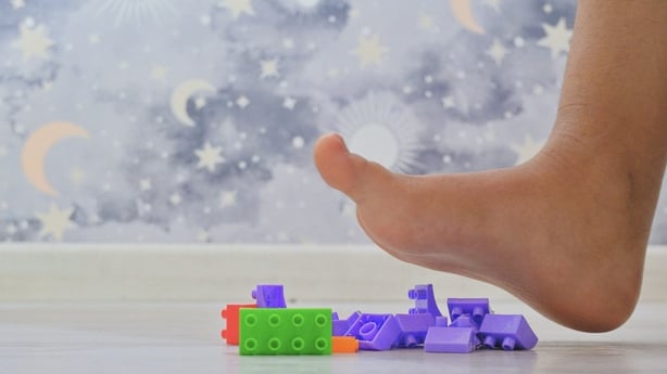 foot stepping on Lego