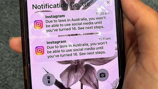 A teenager holds a mobile phone displaying a message from social media platform Instagram