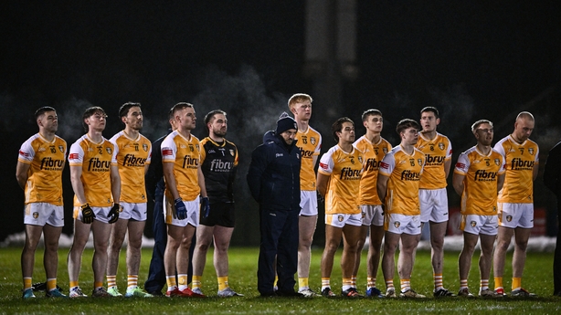 7 January 2026; Antrim manager Mark Doran, centre, stands with his players for the playing of Amhrán na bhFiann before the Bank of Ireland Dr McKenna Cup match between Derry and Antrim at Derry GAA Centre of Excellence in Owenbeg, Derry. Photo by Ben McShane/Sportsfile