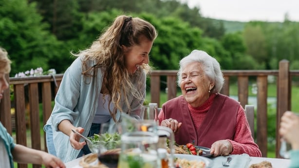 Family barbecue in backyard. Multigenerational family come together, enjoying grilled food and spending quality time outdoors together.