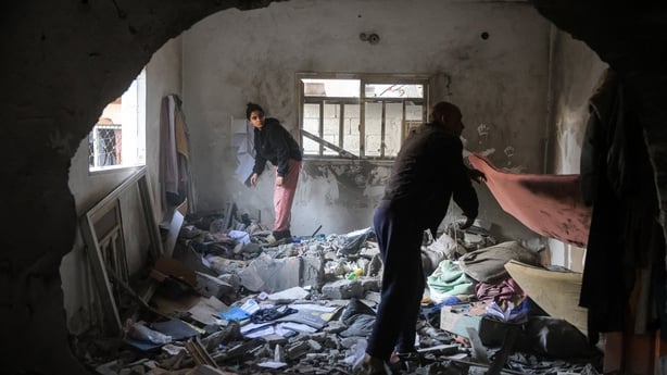 Palestinians salvage items from a house after an Israeli military attack