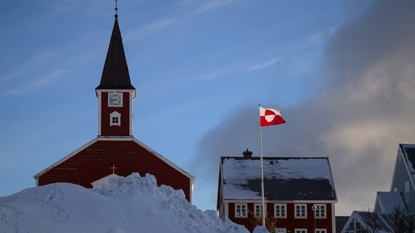 The flag of Greenland flies next to the Church of Our Saviour in Nuuk, Greenland