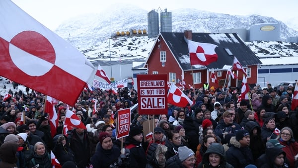 People hold Greenlandic flags and placards as they gather by the United States Consulate to march in protest against US President Donald Trump