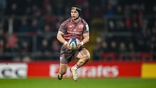 Action shot of Munster Rugby players in red jerseys contesting a ruck during a high-stakes match.