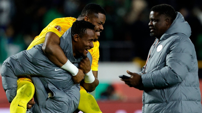 Nigeria's goalkeeper #16 Amas Obasogien carries Nigeria's goalkeeper #23 Stanley Nwabali after victory in the Africa Cup of Nations (CAN) third place football match between Egypt and Nigeria at the Mohammed V Stadium in Casablanca on January 17, 2026. (Ph