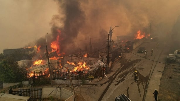 Smoke and flames billow from burning houses during a wildfire in Concepcion, Chile
