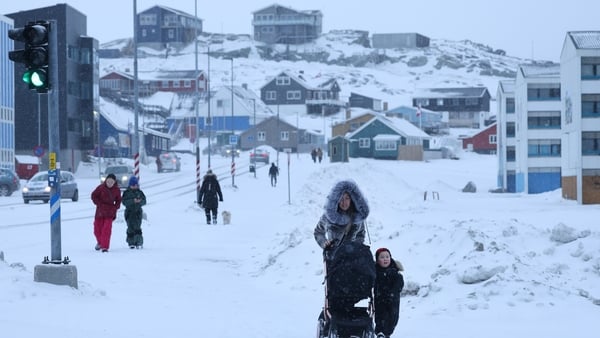 People walk through fresh snow in the city center in Nuuk, Greenland