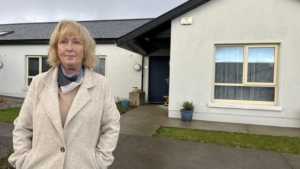 Helen Broad standing in front of her bungalow