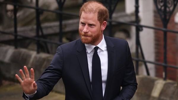 Prince Harry waves as he arrives at court in london