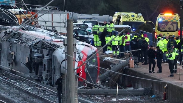 Members of the Spanish Civil Guard, along with other emergency personnel, work next to one of the trains involved in the accident