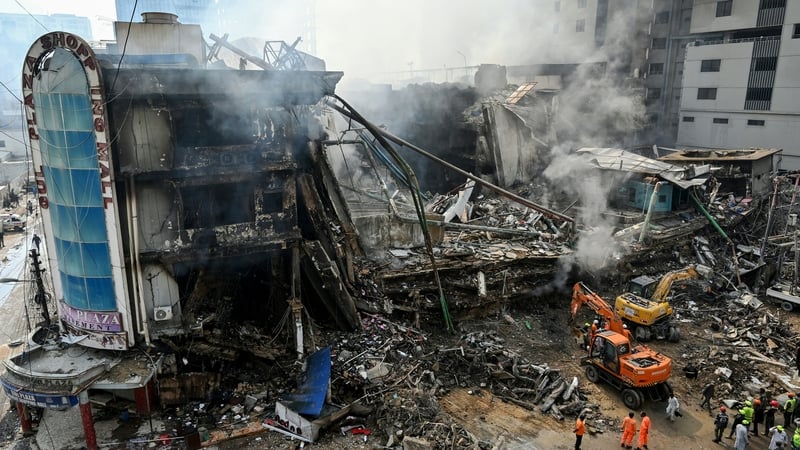 Rescue workers search amid the debris at the Karachi mall using excavators