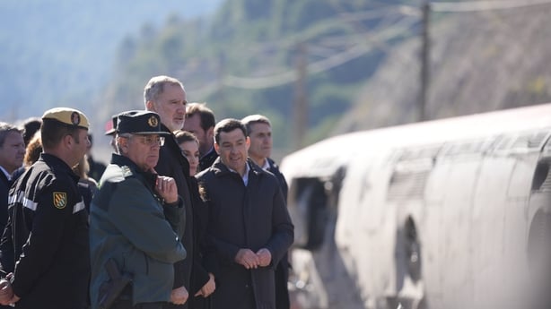 King Felipe VI and Queen Letizia, among a group of people at a train crash site in spain