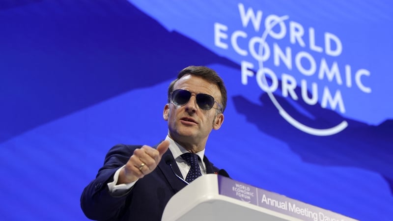 Emmanuel Macron wearing sunglasses gestures as he delivers a speech