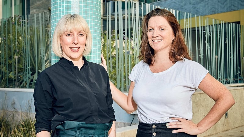Two business women pose for a photo