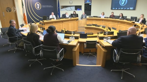 people sit around a circular desk in an office setting