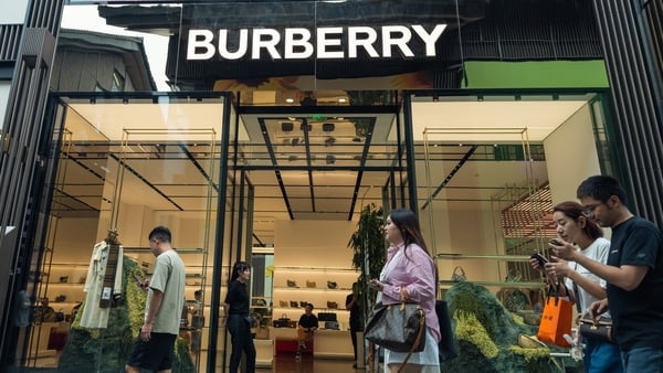 Pedestrians walk past a Burberry store in China
