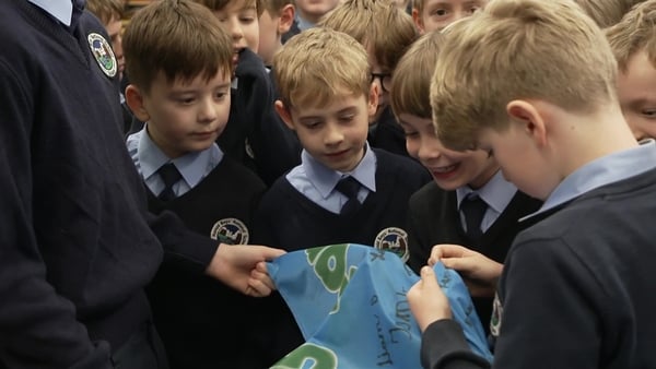School children look at a special flag.