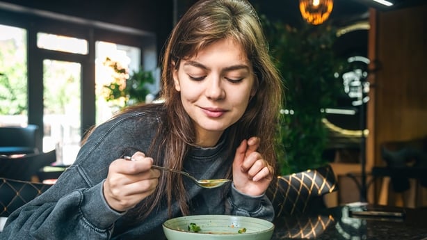 woman eating vegetable soup in a cafe