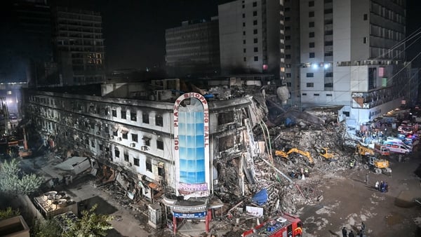 Rescue workers search for bodies in the rubble after a massive fire at a Pakistan shopping mall
