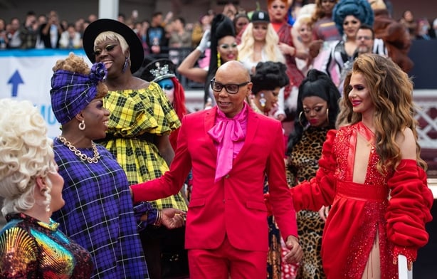 RuPaul posing with a group of drag queens