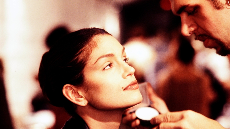 Makeup artist Kevyn Aucoin applies makeup on model Cindy Crawford.