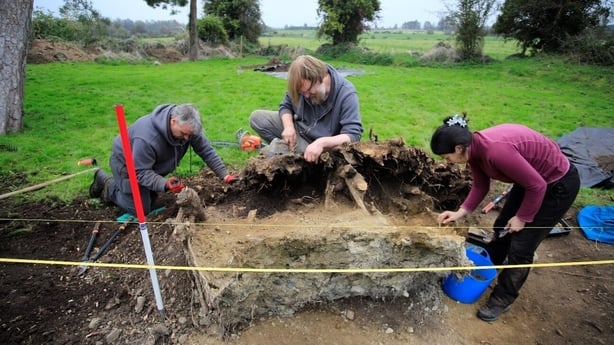 People excavate a site 