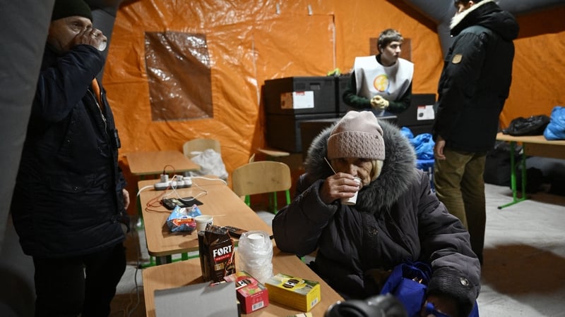 People warm themselves in an emergency service tent in a residential neighbourhood of Kyiv yesterday