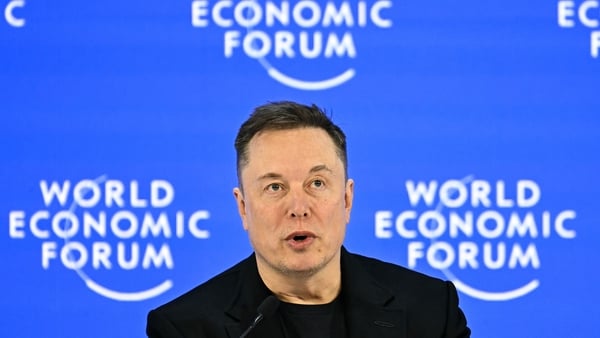 Elon Musk pictured with the World Economic Forum signage behind him